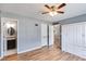 Bedroom featuring wood-look floors, closet, ceiling fan, and adjacent access to bathroom at 447 Wallace Way, Rockmart, GA 30153