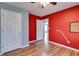 Bright bedroom features wood-look flooring and a vibrant red accent wall at 447 Wallace Way, Rockmart, GA 30153