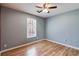 Bedroom featuring wood-look floors, natural light from large window, neutral wall color and ceiling fan at 447 Wallace Way, Rockmart, GA 30153