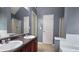 This is a bathroom featuring a bathtub, shower, double vanity, large mirror, and neutral colored paint at 3479 Lake Forge Dr, Fairburn, GA 30213