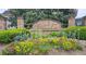Community entrance sign with stone pillars, manicured landscaping, and colorful flowers at 3479 Lake Forge Dr, Fairburn, GA 30213