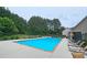 Community pool with lounge chairs and lush landscaping at 3479 Lake Forge Dr, Fairburn, GA 30213