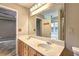 Well-lit bathroom featuring a double sink vanity, a large mirror, tile flooring, and a view of the shower and tub at 604 Lexington Way, Woodstock, GA 30189