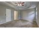Large main bedroom featuring carpeted floors, neutral walls, a trey ceiling, a ceiling fan, and entry to the walk-in closet at 604 Lexington Way, Woodstock, GA 30189