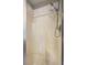 An enclosed shower with a handheld shower head and built-in shelves for toiletries at 604 Lexington Way, Woodstock, GA 30189