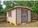 Wooden storage shed with double doors and a window in the backyard at 604 Lexington Way, Woodstock, GA 30189