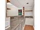 Compact bar area with granite countertop, white cabinetry, and hardwood flooring, perfect for entertaining guests at 902 Preserve Bluff Dr, Buford, GA 30518