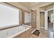 Large tub and a glass-enclosed shower in this bright, modern bathroom at 902 Preserve Bluff Dr, Buford, GA 30518