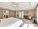 Large carpeted bedroom with a tray ceiling and fan, plus ample closet space at 902 Preserve Bluff Dr, Buford, GA 30518