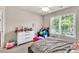 Well-lit bedroom with a large window, plush bedding, and colorful accents at 902 Preserve Bluff Dr, Buford, GA 30518