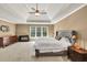 Light-filled carpeted bedroom with modern ceiling fan, large window, and neutral decor at 902 Preserve Bluff Dr, Buford, GA 30518