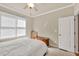 Bright bedroom featuring neutral walls, white trim, ceiling fan, and a large window for natural light at 902 Preserve Bluff Dr, Buford, GA 30518
