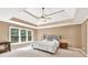 Spacious main bedroom features a tray ceiling with fan, neutral walls, and bright windows at 902 Preserve Bluff Dr, Buford, GA 30518