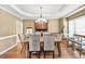 Formal dining room with hardwood floors, stylish chandelier, tray ceiling, and views to backyard at 902 Preserve Bluff Dr, Buford, GA 30518