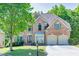 Charming brick home with two-car garage, manicured lawn, and lush landscaping offers great curb appeal at 902 Preserve Bluff Dr, Buford, GA 30518