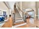 Elegant foyer with hardwood floors, staircase with iron spindles, and views to the dining and living areas at 902 Preserve Bluff Dr, Buford, GA 30518