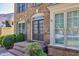 Close-up of the front entrance showing the brick facade, multi-paneled door, and manicured bushes at 902 Preserve Bluff Dr, Buford, GA 30518