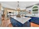 Open concept kitchen with blue cabinets, an island, stainless appliances, open shelving, and hardwood floors at 902 Preserve Bluff Dr, Buford, GA 30518