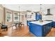 Eat-in kitchen featuring blue cabinets, hardwood floors, an island, and access to the outside at 902 Preserve Bluff Dr, Buford, GA 30518