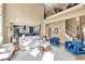 Bright living room featuring a modern blue kitchen, staircase, and white sectional sofa at 902 Preserve Bluff Dr, Buford, GA 30518