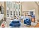 Spacious living room with soaring windows, fireplace, built-ins, and comfortable seating area at 902 Preserve Bluff Dr, Buford, GA 30518