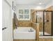 Well-lit bathroom features a built-in tub, glass shower, and stylish tiling for a luxurious feel at 1055 Chelsey Way, Roswell, GA 30075