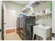 Functional laundry room featuring a modern washer, dryer, utility sink, and ample shelving for storage at 1055 Chelsey Way, Roswell, GA 30075
