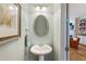 Well-lit half bathroom features a pedestal sink and decorative mirror at 11187 Calypso Dr # 12, Alpharetta, GA 30009