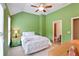 Cozy bedroom with green walls, a ceiling fan, and a window providing natural light at 11187 Calypso Dr # 12, Alpharetta, GA 30009