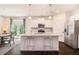 Bright kitchen with granite island, stainless appliances, white cabinets, and dining area with access to the outdoors at 118 Woodhouse Cir, Acworth, GA 30102