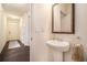 Stylish powder room featuring a pedestal sink, decorative mirror, and hardwood flooring at 118 Woodhouse Cir, Acworth, GA 30102