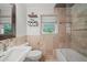 Neutral-toned bathroom features stone tile surround, shower, and floating shelves above the toilet at 331 Lakemoore Ne Dr # C, Atlanta, GA 30342
