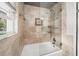 Modern bathtub with clear glass shower door and neutral-toned stone tile surround at 331 Lakemoore Ne Dr # C, Atlanta, GA 30342