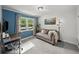 Bright bedroom with a grey couch, desk, and natural light from the window at 331 Lakemoore Ne Dr # C, Atlanta, GA 30342