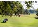 Picturesque golf course with lush green fairways, mature trees, and golfers enjoying a sunny day on the green at 331 Lakemoore Ne Dr # C, Atlanta, GA 30342