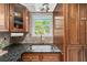 Kitchen view displaying dark granite countertops, a stainless steel sink, and wood cabinetry at 331 Lakemoore Ne Dr # C, Atlanta, GA 30342