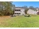 Large backyard with a well-manicured lawn, patio with seating, and fire pit, perfect for outdoor entertaining at 100 Lantana Dr, Locust Grove, GA 30248