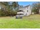 Expansive backyard featuring a fire pit, screened porch, lush greenery, and ample space for recreation at 100 Lantana Dr, Locust Grove, GA 30248