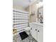 Well-lit bathroom with a black and white patterned floor, framed mirror, and patterned shower curtain at 100 Lantana Dr, Locust Grove, GA 30248