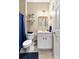 Well lit bathroom featuring white cabinets and toilet with contrasting blue accents at 100 Lantana Dr, Locust Grove, GA 30248