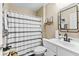 Well-lit bathroom featuring black and white patterned floor tiles and a shower with decorative curtain at 100 Lantana Dr, Locust Grove, GA 30248