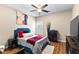 Cozy bedroom showcasing a bed with colorful pillows, dark wood furniture, and ceiling fan at 100 Lantana Dr, Locust Grove, GA 30248
