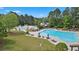 An aerial view of the community pool, featuring a variety of pool types, seating, and waterpark area at 100 Lantana Dr, Locust Grove, GA 30248