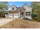 Charming two-story home featuring a stone facade, two-car garage, and well-manicured front yard at 100 Lantana Dr, Locust Grove, GA 30248