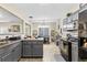 Well-lit kitchen features gray cabinets, a range, microwave, and views into the dining area at 100 Lantana Dr, Locust Grove, GA 30248