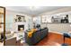 Open-concept living room featuring a fireplace, hardwood floors, and seamless flow to the modern kitchen at 100 Lantana Dr, Locust Grove, GA 30248