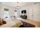 Spacious main bedroom with natural light, TV, chandelier, and hardwood floors at 1076 Green St, Roswell, GA 30075
