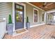 Inviting front porch boasts brick flooring and a view of the landscaped front yard at 1076 Green St, Roswell, GA 30075