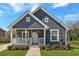 Charming home featuring a stylish gray exterior, covered front porch and well manicured lawn, creating inviting curb appeal at 345 Wellington Sw St, Atlanta, GA 30310