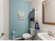 Powder room featuring blue accent wall, pedestal sink and modern fixtures at 5920 Hart Way, Cumming, GA 30028